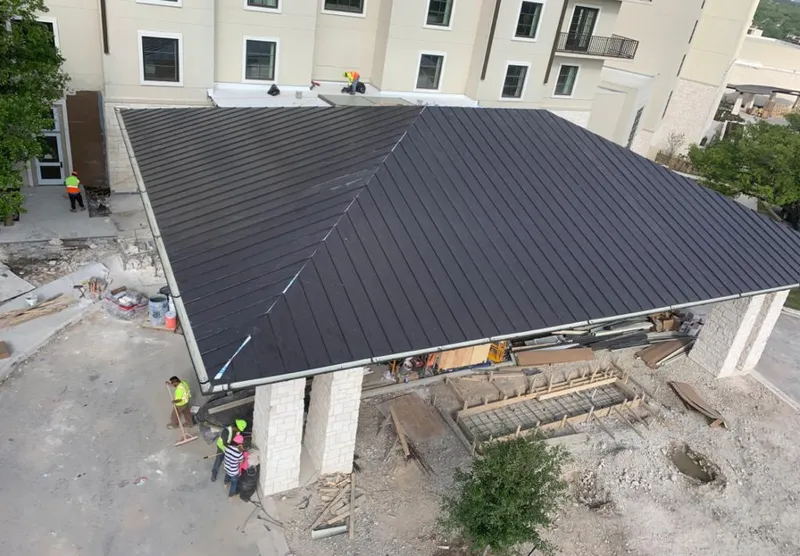 Metal roofing installation team working on a commercial building in Lackland AFB